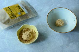 将糯米圆子捞出，小碗中倒入适量的黄豆粉。夹一个糯米圆子放入黄豆粉中沾满黄豆粉即可。