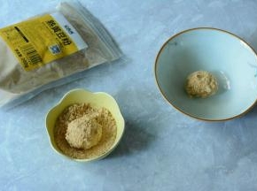 将糯米圆子捞出，小碗中倒入适量的黄豆粉。夹一个糯米圆子放入黄豆粉中沾满黄豆粉即可。