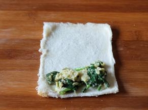 在吐司片一边放入适量菠菜鸡蛋；