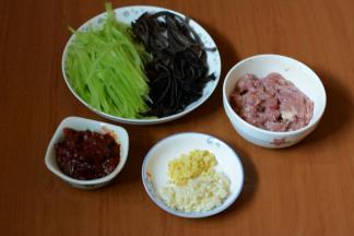 猪肉切丝加入少许淀粉和生抽腌制。青笋去皮，切丝。木耳提前泡发好，洗干净切丝。姜蒜切细碎。