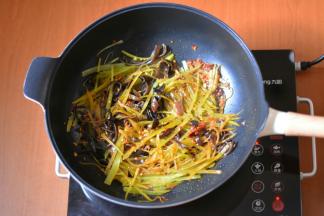 接着加入青笋和木耳翻炒出香。