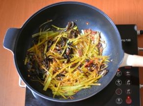 接着加入青笋和木耳翻炒出香。