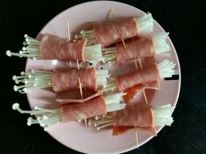 把金针菇分成均匀的几份，用培根卷起来，用牙签固定。培根的长度长一些，这样卷起来才不容易掉。