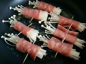 放入金针菇培根卷，小火煎。