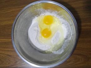 3、面粉中加入两个鸡蛋。
