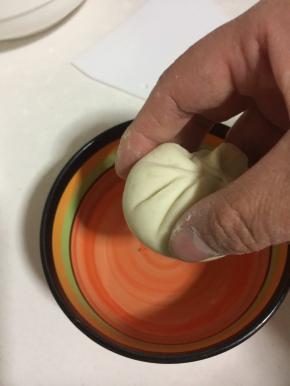 包好的小笼包底部在清水中蘸一下。