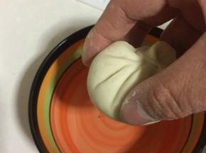包好的小笼包底部在清水中蘸一下。