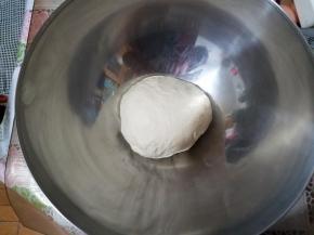 厨师机揉面10分钟后加入橄榄油继续揉成一个面团。