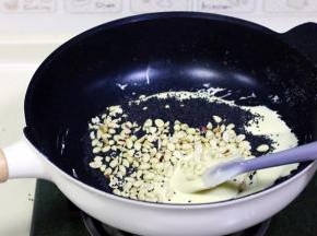 关火，花生仁和黑芝麻，迅速翻拌均匀，用手摸着干而不粘手即可。