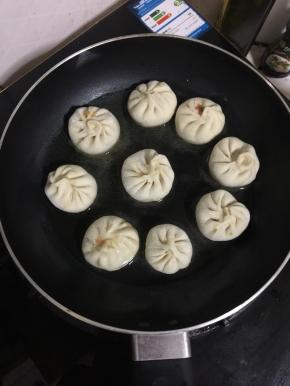 放入包好的迷你小笼包，调小火煎一分钟左右！底部煎至微黄即可！