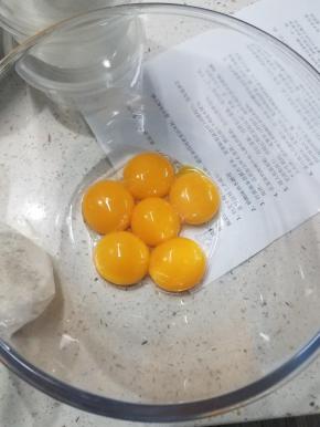 先将鸡蛋的蛋黄、蛋白分离至2个盘内，再将牛奶和奶油奶酪放在大碗上，隔水加热，搅拌均匀至光滑无颗粒，再次加入黄油，搅拌至完全溶化。