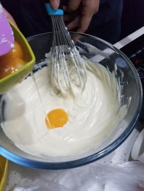 然后离开热水，分次加入六个蛋黄，加一个搅拌均匀一个。
