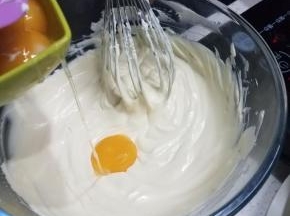 然后离开热水，分次加入六个蛋黄，加一个搅拌均匀一个。