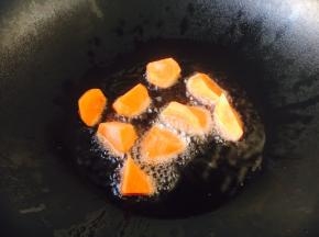 热锅凉油，放入胡萝卜块煸炒1分钟。
