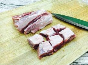 牛腩肉先用清水浸泡1个小时，然后挤出血水，洗干净。 先顺着牛腩肉的纹理切成条，然后再逆着牛腩肉的纹理切成麻将大小的块。