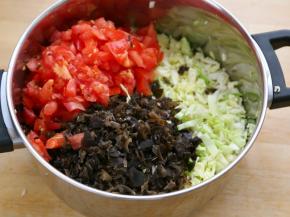 西红柿和木耳也切碎放入盛包菜锅里，轻轻地抓一抓拌匀。