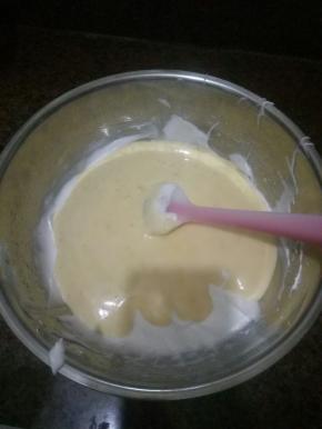 取三分之一蛋白加入到蛋黄糊中，用橡皮刮刀从底部往上翻拌均匀，不可划圈，再把翻拌好的蛋黄糊到回蛋白中，翻拌均匀，切记不可划圈，以免消泡。