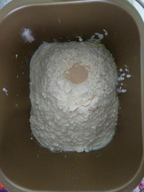 除黄油外，所有材料按照先液体，然后放面粉，面粉上挖个洞埋好酵母，启动面包机iMin程序,20分钟后，加入提前切小块软化好的黄油,继续揉面20分钟,揉至完全阶段