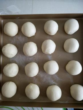 取出面团，平均分割成16等份，把每个小面团都揉圆，依次放入烤盘，中间隔开距离（也可包入豆沙馅）