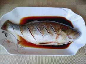 将鲈鱼放入盘中，加入料酒，生抽腌制15分钟。