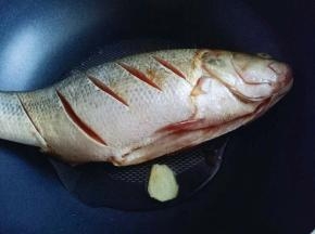 锅中加入油，放入姜山，再放入腌制好的鲈鱼，煎至两面微黄盛出。