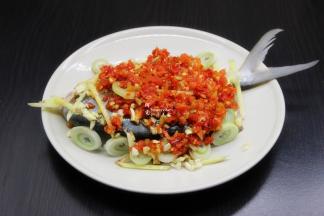 腌制好的鱼，鱼肚内塞入几片生姜、蒜，把生姜、大蒜、蒜、剁椒放在鱼上面；