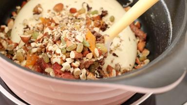 加入前面准备好的混合坚果果干，用力的戳进棉花糖，如果室内温度低凝固的快就开小火稍微加热软化一下。