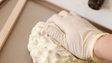 取出后，略微放凉一些后，用力再揉几次。保证果干和牛轧糖体可以混合接触的更紧实