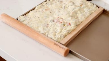 放在不粘烤盘上，用手用力按平抹开，可以用工具辅助整理边缘整齐