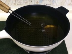 开大火，往锅内倒入食用油，把油饼勺一起放入锅内加热。