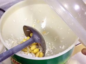 把混合好的黄豆、大米和水分次慢慢加入到磨浆机内研磨。