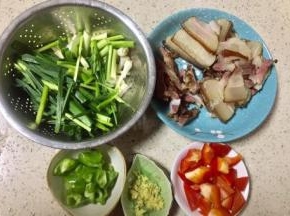 煮腊肉的时候把蒜苗洗净后切段，径和叶要分开放，青椒和红椒切小块，老姜切姜米，腊肉如有单独的瘦肉和大块肉分开放