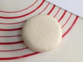 把包好的饼轻轻按压，然后用擀面杖擀成厚度为1厘米的圆饼状，也可以用刮板直接按压成型。