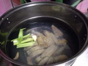锅内加水冷水倒入腊鸡，加入葱段、姜片煮开
