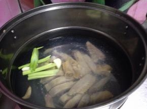 锅内加水冷水倒入腊鸡，加入葱段、姜片煮开