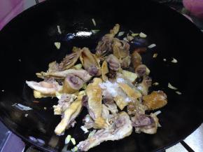 转大火倒入腊鸡、糖、料酒迅速翻炒