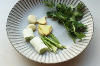 香菜根切段，葱切段，姜切片，大蒜拍扁。