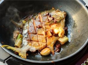 鱼再翻面个煎一会，使酱料裹满鱼身，煎入味。