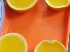 将橙子液倒入橙子壳中，静置到完全凝固。
