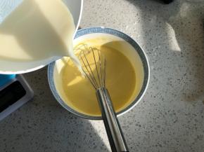 自制的无糖豆浆烧开，趁热分次加入蛋黄中，一边倒入一边搅拌
