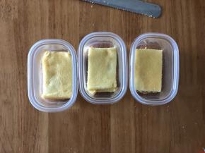 把蛋糕切割为和盒子一样大小的长方形片，先放一片蛋糕在盒子底部