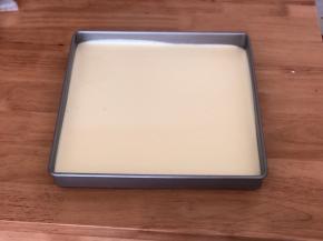 最后把翻拌均匀的蛋糕糊倒入28.4cm*28.4cm的方形不粘烤盘中，在桌上轻轻磕几下震出大气泡