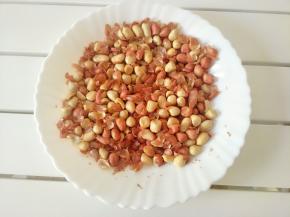 烤好的花生倒在盘子里，稍凉后用手搓皮