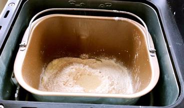 将牛奶：鸡蛋、盐和糖对角放，牛奶、高筋面粉、全麦面粉依次放入面包机内，再在中间挖一小洞，放入酵母粉，启动揉面功能揉面15分钟