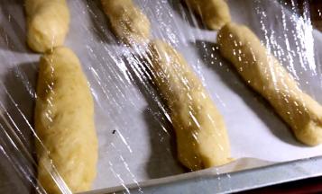 放入铺有油纸的烤盘上，盖上保鲜膜醒发至2到3倍大