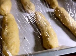 放入铺有油纸的烤盘上，盖上保鲜膜醒发至2到3倍大