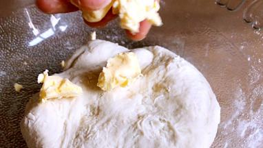 用手揉成面团，加入黄油继续揉面至扩展状态