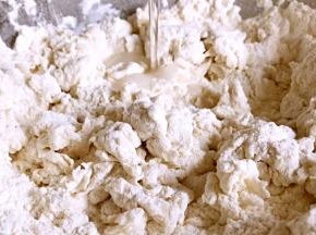 将清水慢慢加入到高筋面粉里，边加水边搅拌成絮状