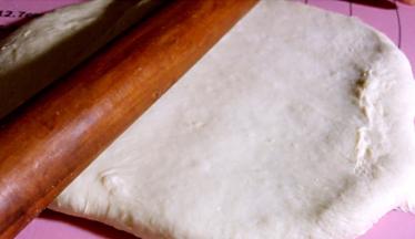 将醒好的面团擀成饼皮（饼皮比披萨盘大一圈）