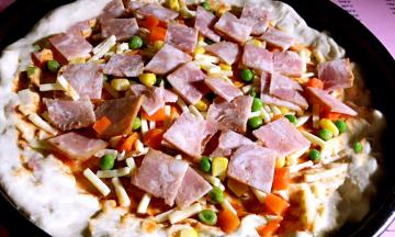 接着撒入红萝卜丁、玉米粒、青豆、培根块